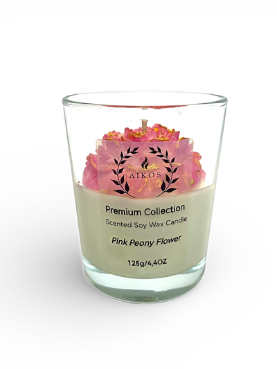 Świeca sojowa zapachowa z różowym kwiatem piwonii.